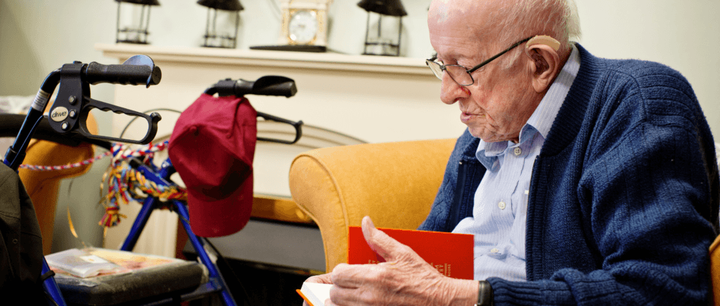 Elderly man sits down to read The Poetry Pharmacy