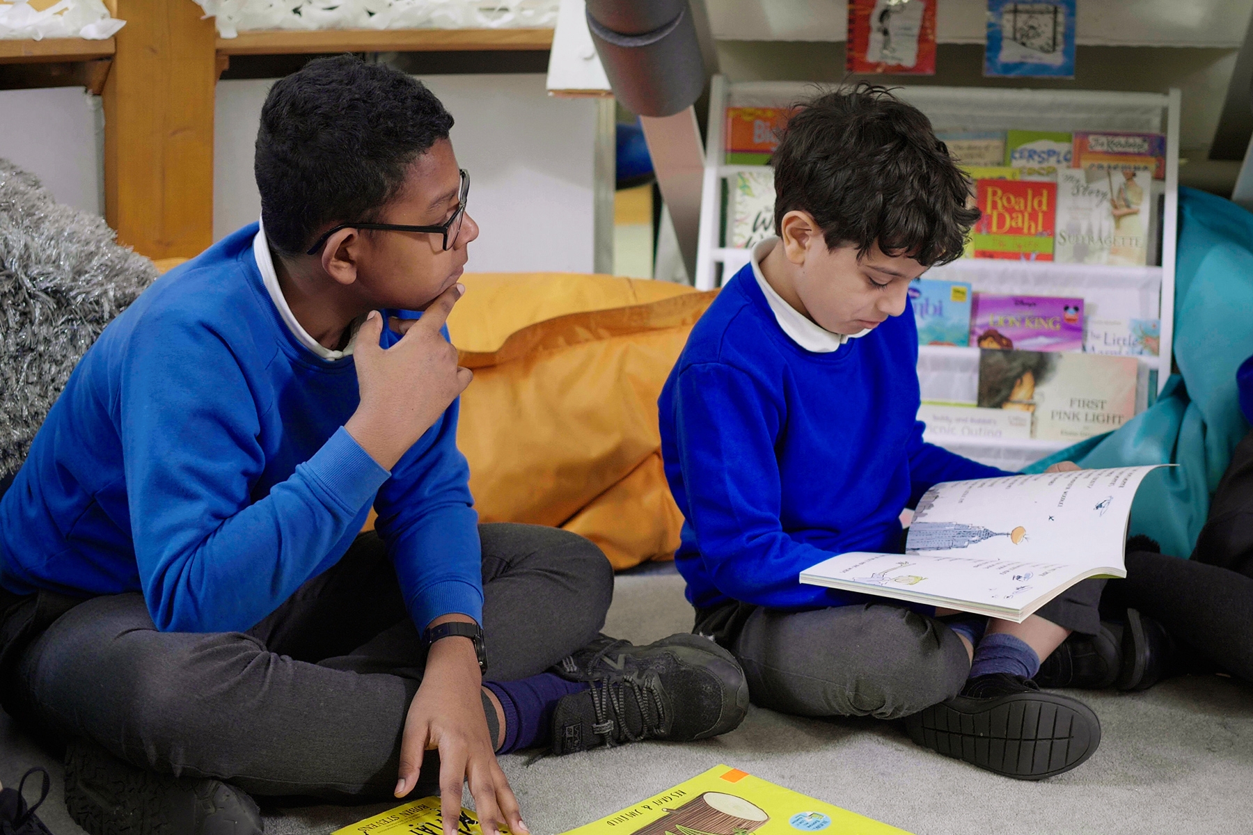 Two boys sit and read a book