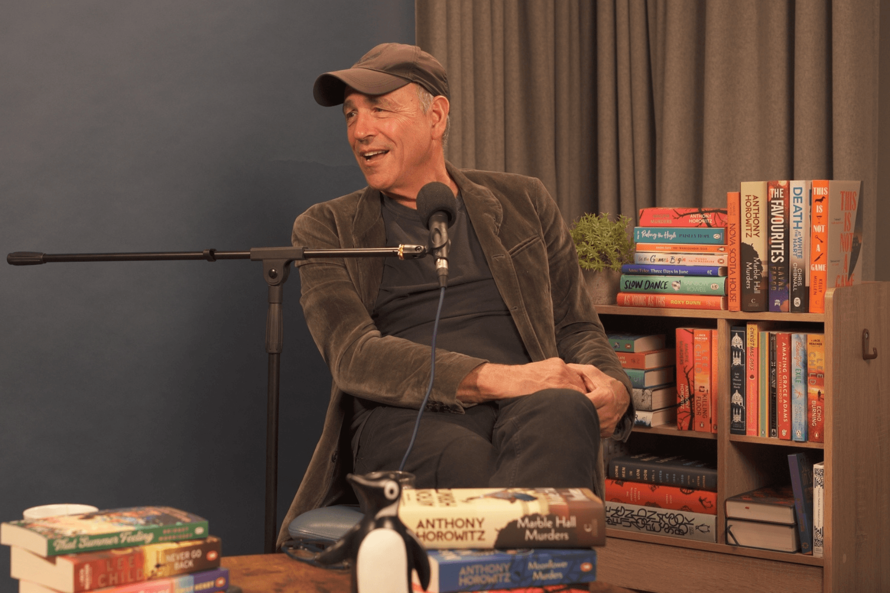 Marble Hall Murders author Charlie Porter sitting and talking in the book-filled Penguin Podcast studio