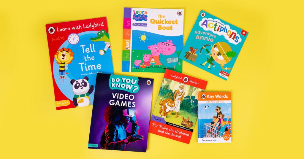 A photo of a selection of Ladybird Education books on top of a bright yellow background
