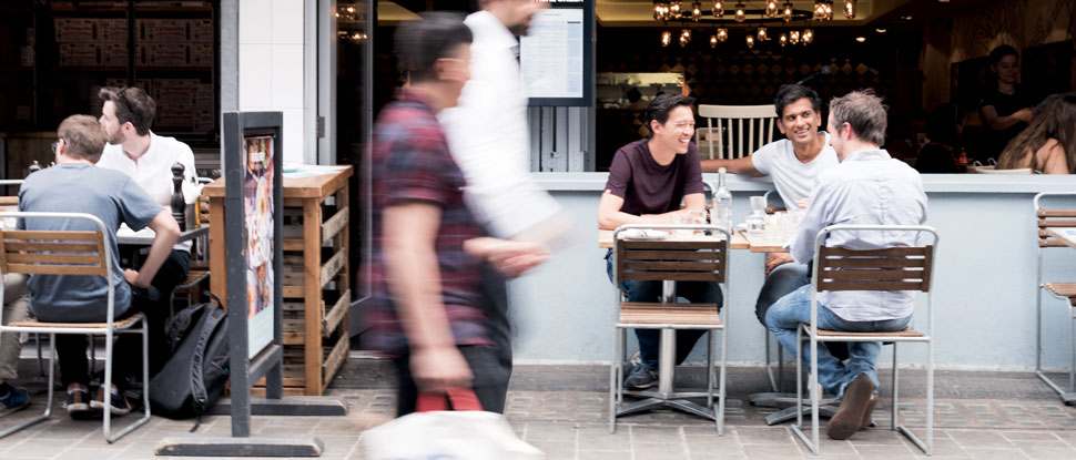 A group of men chatting outside a café