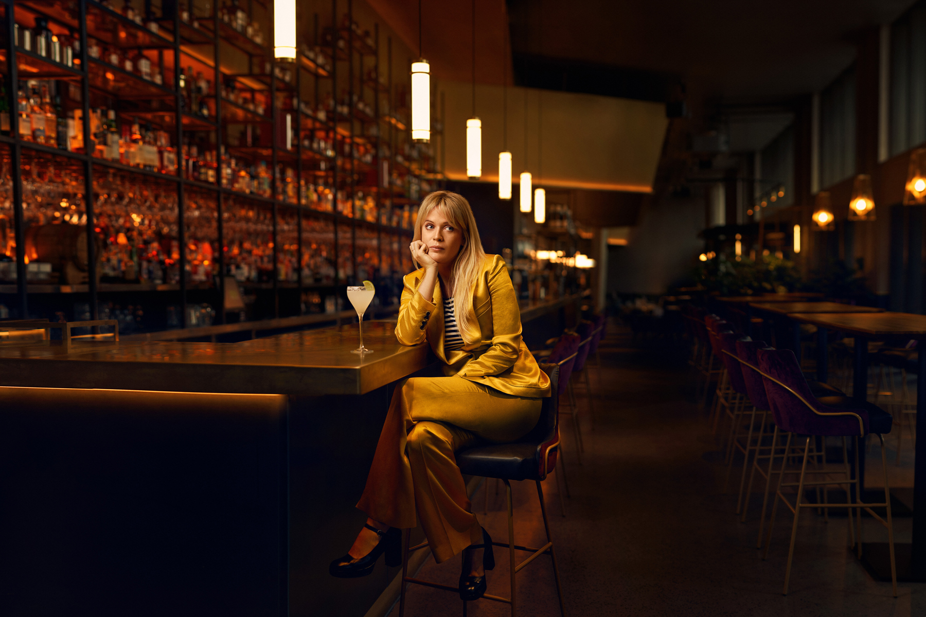 Dolly Alderton posed against a cocktail bar