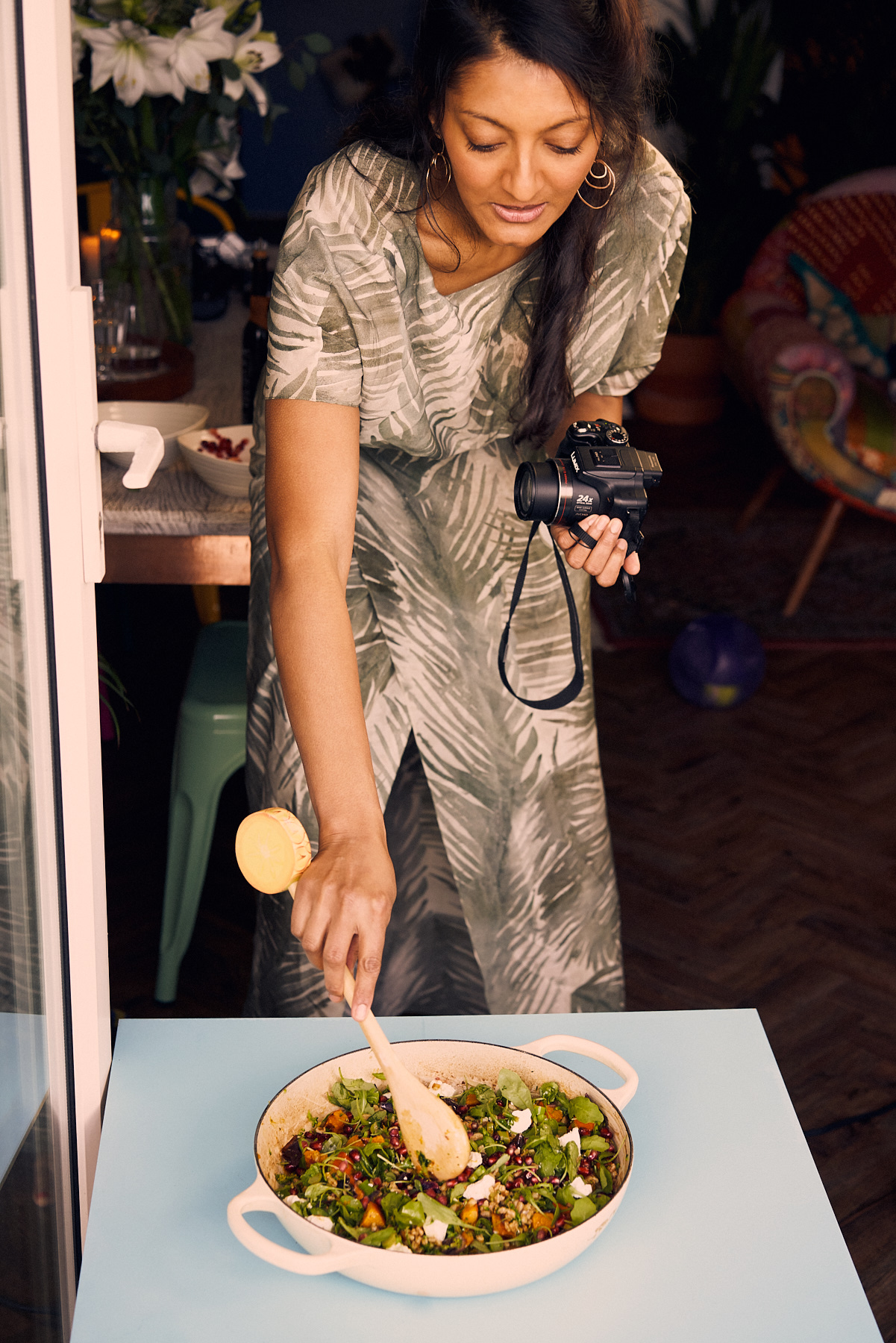 Rukmini Iyer leans over a plate while holding a camera
