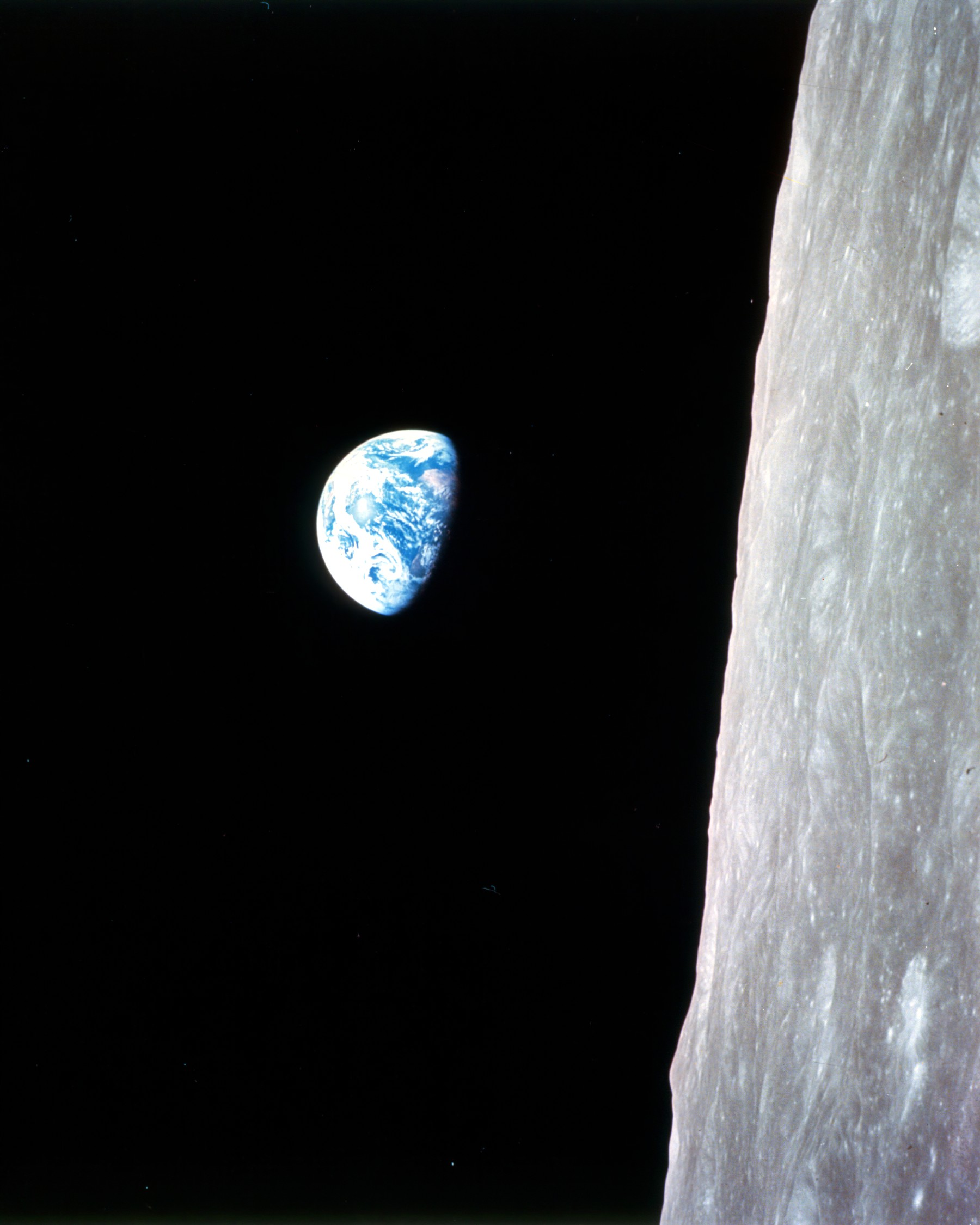 The iconic photo 'Earthrise', of the planet Earth against the blackness, with the surface of the moon in the foreground.