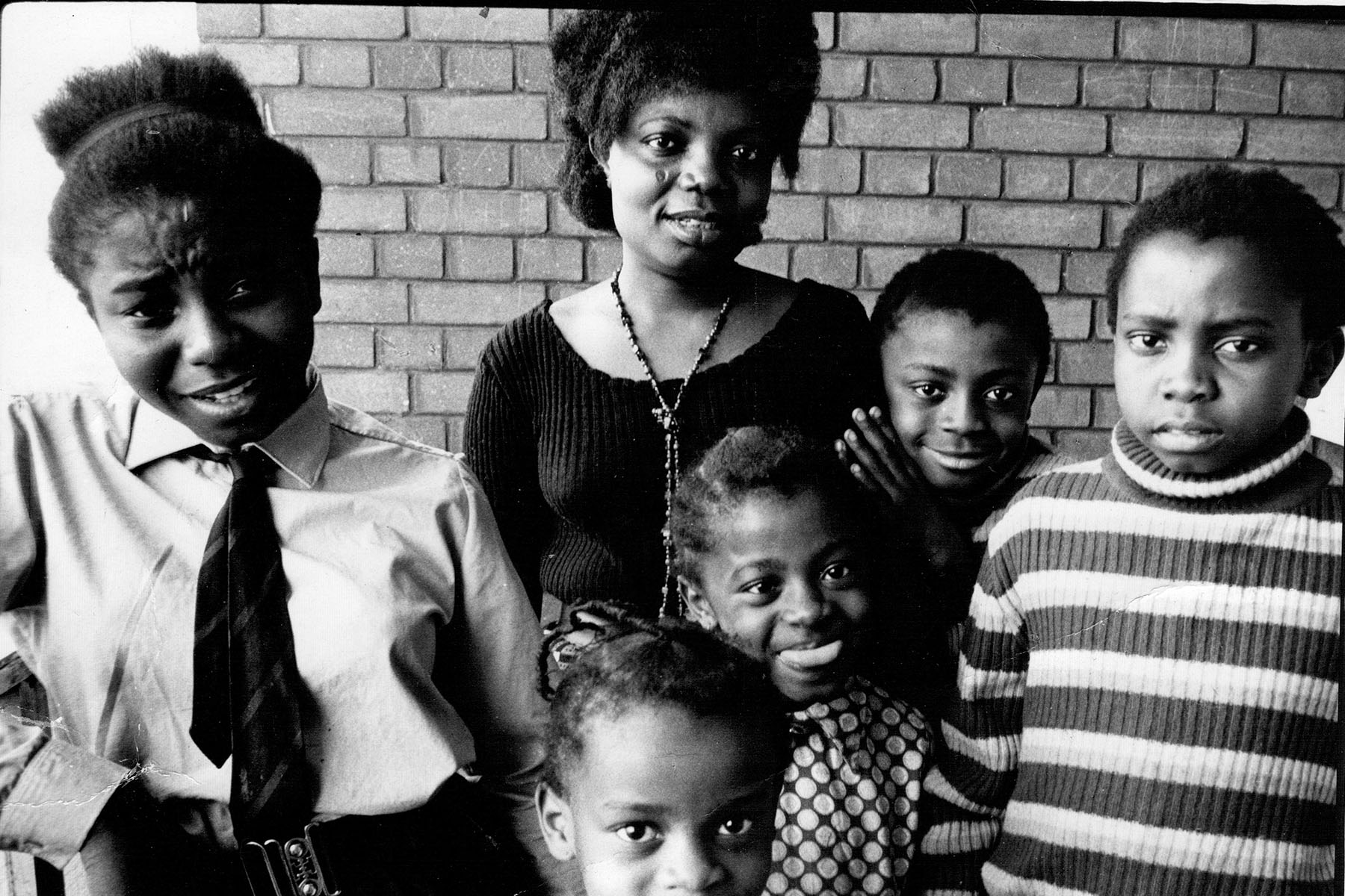 A black-and-white photograph of Buchi Emecheta with her children
