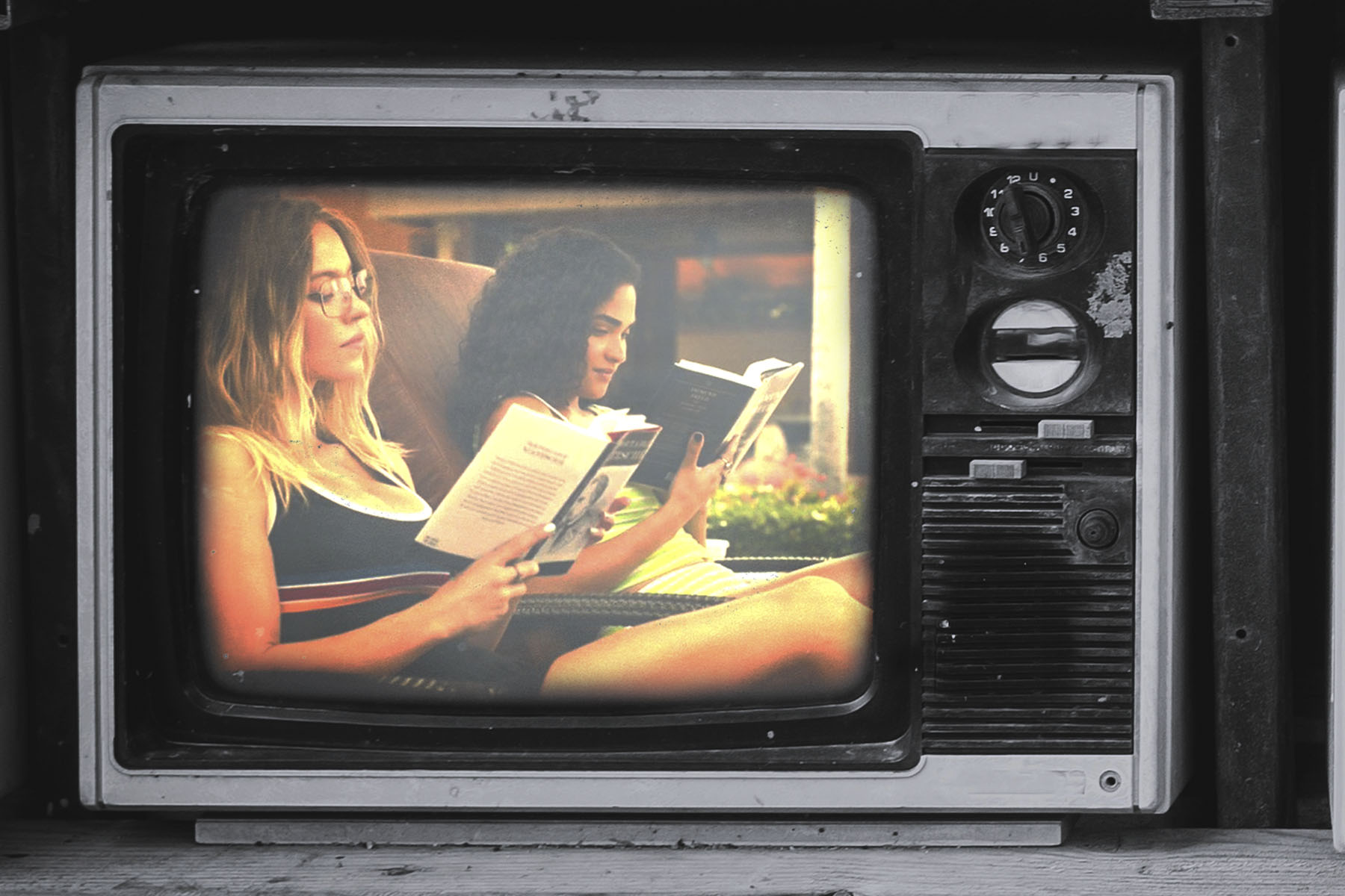 A still from television show The White Lotus of Paula and Olivia reading by the pool