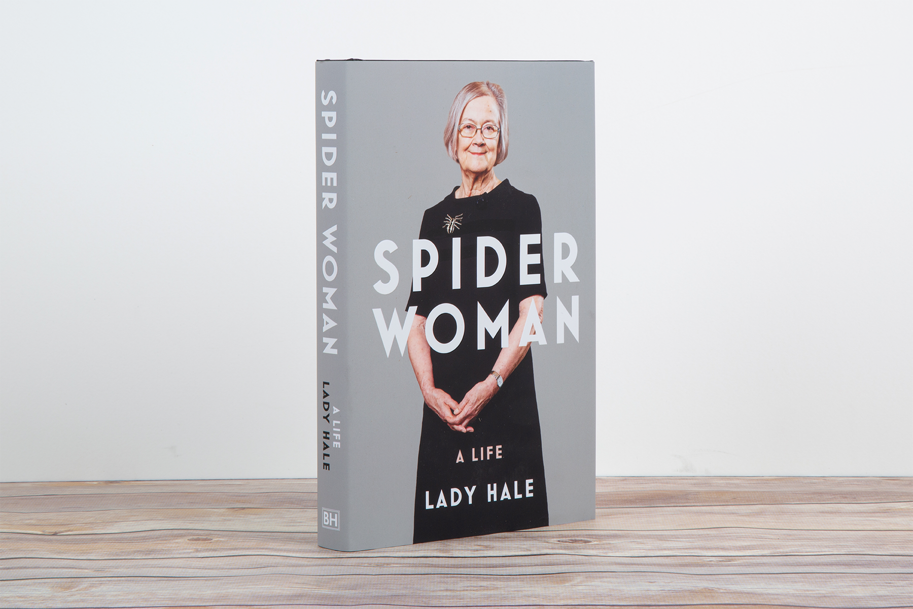 A photo of Lady Hale's memoir 'Spider Woman' on a wood surface against a light grey background.