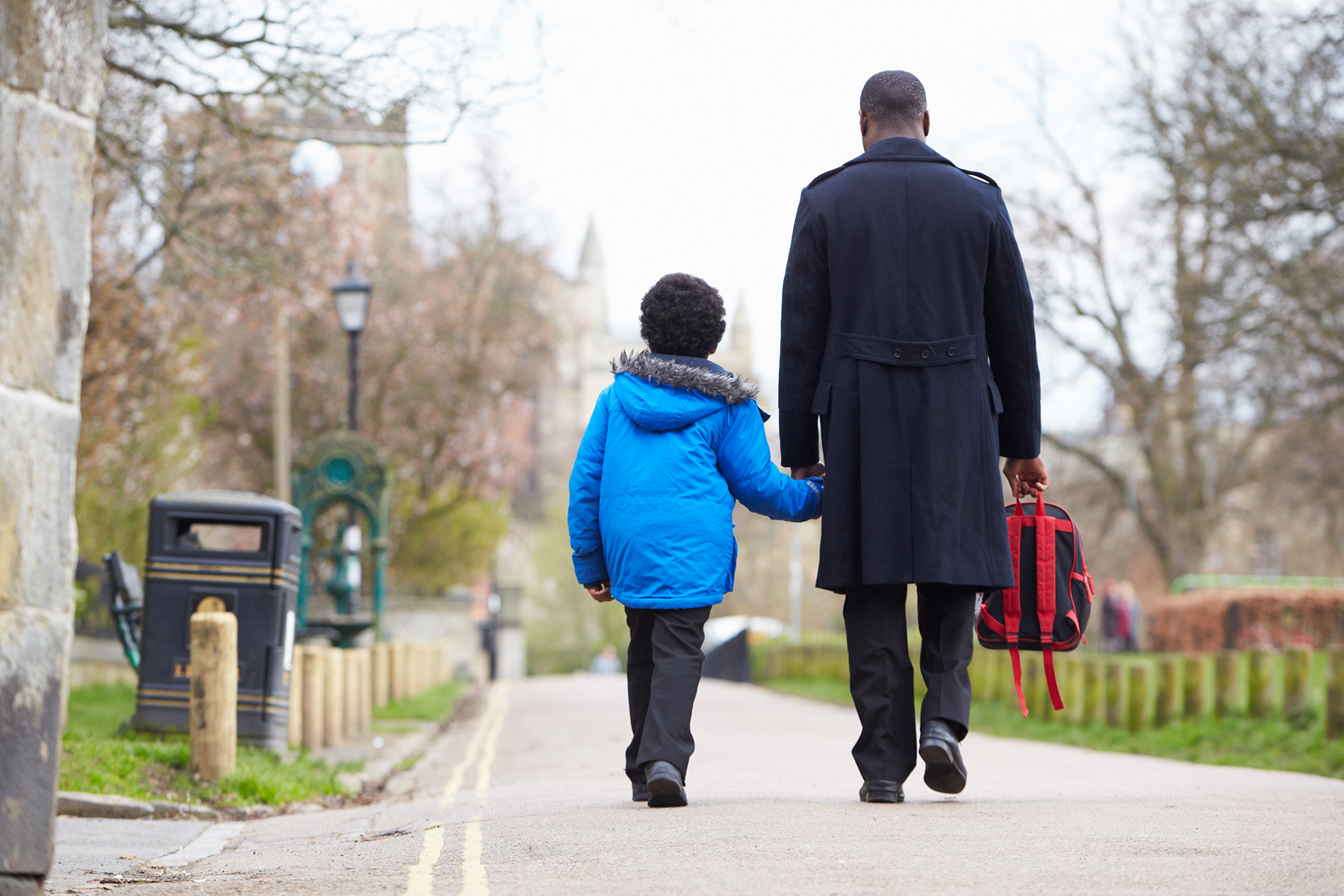 A photo of a father walking his son to school