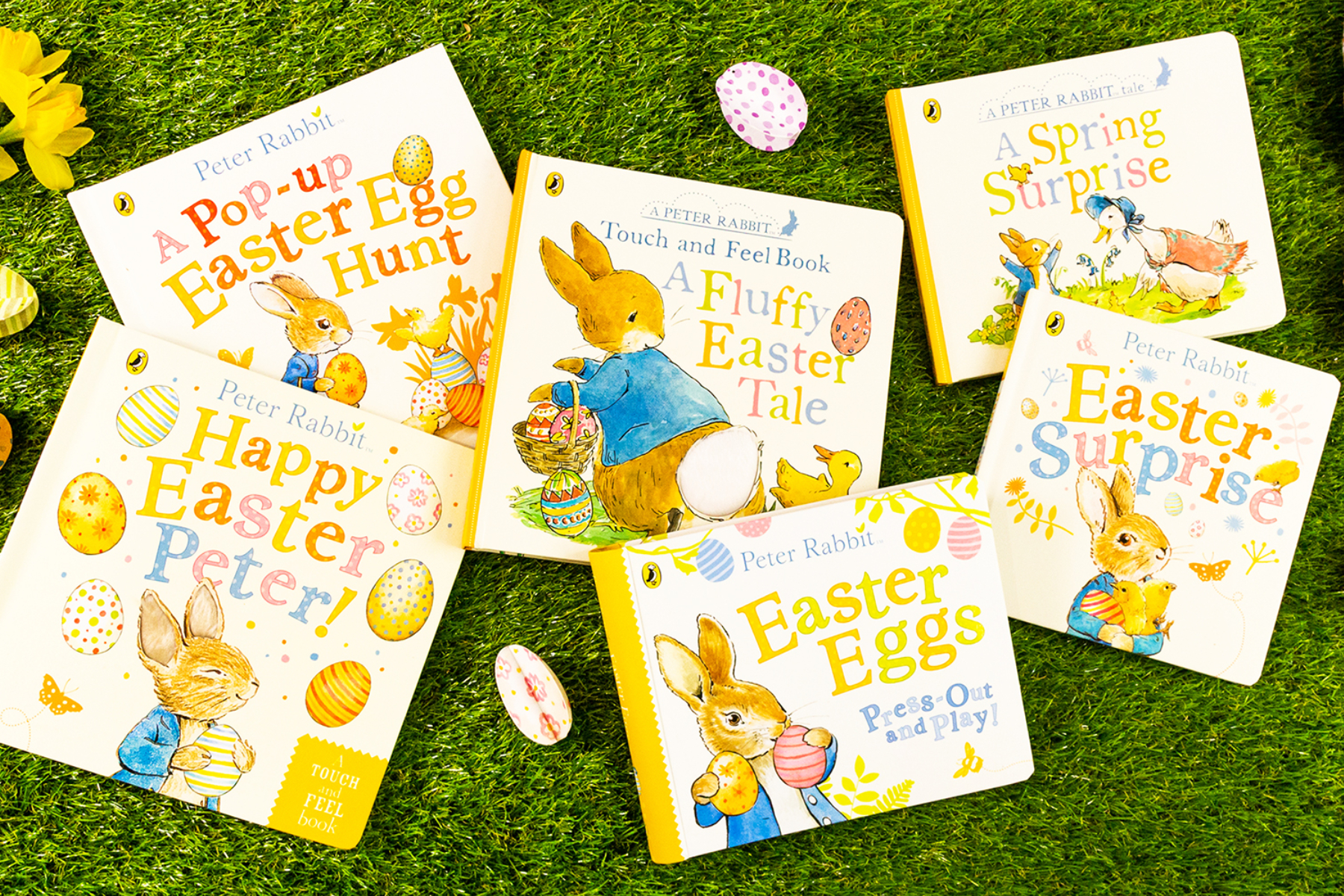 A photo of a selection of Peter Rabbit books on a grassy background