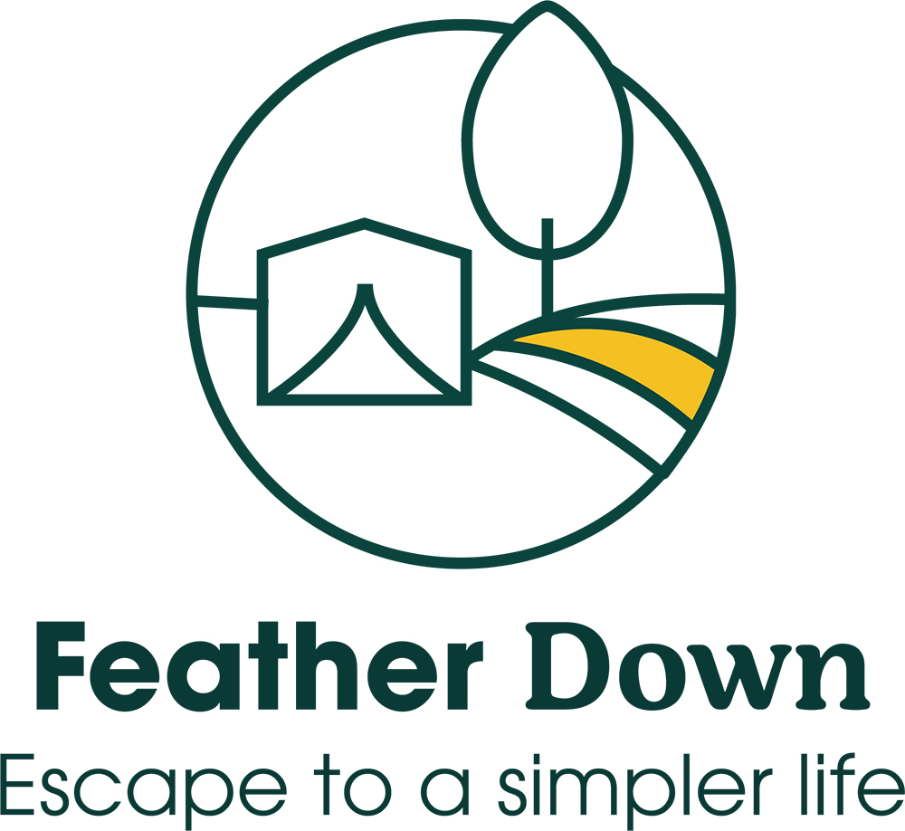 The Feather Down Farms logo. It's a simple line drawing of a tent on a hill with a tree. Underneath are the words 'Feather Down: Escape to a simpler life'